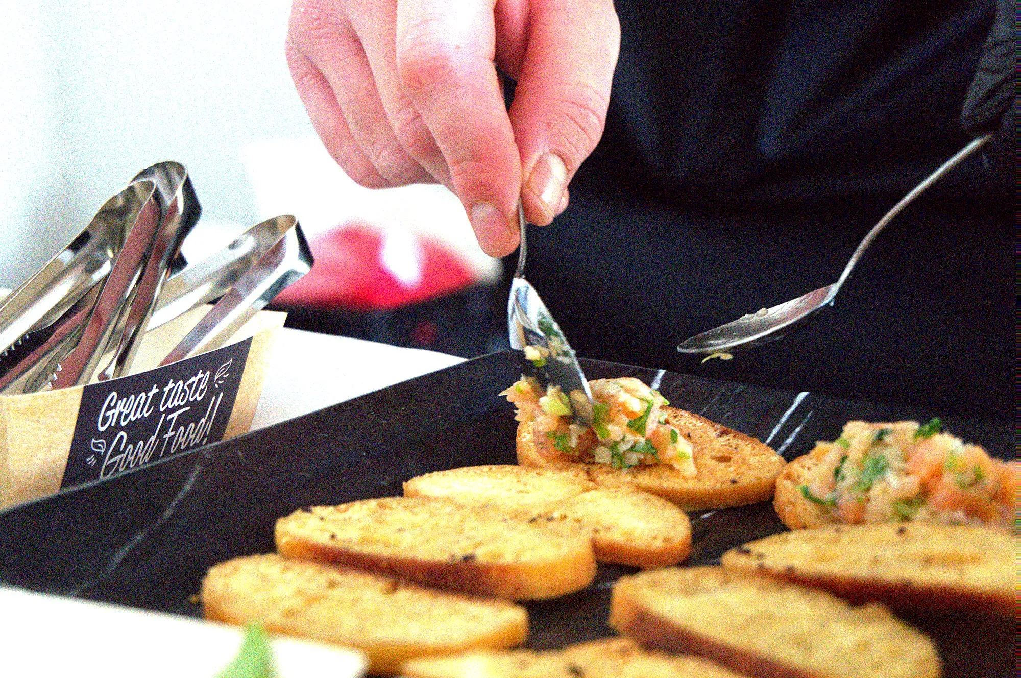 Crostini mit frischem Belag werden von Hand angerichtet